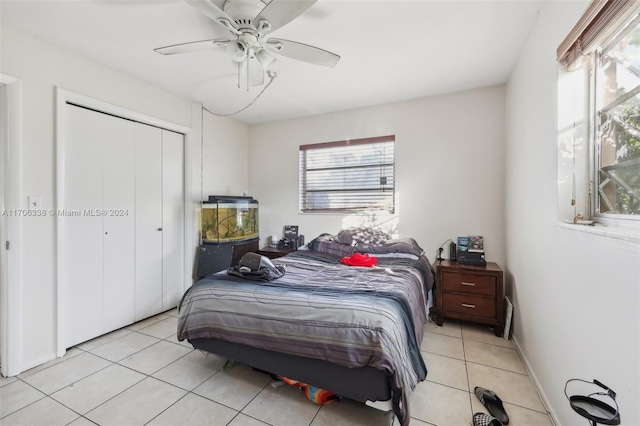 bedroom featuring light tile patterned floors, a closet, and ceiling fan