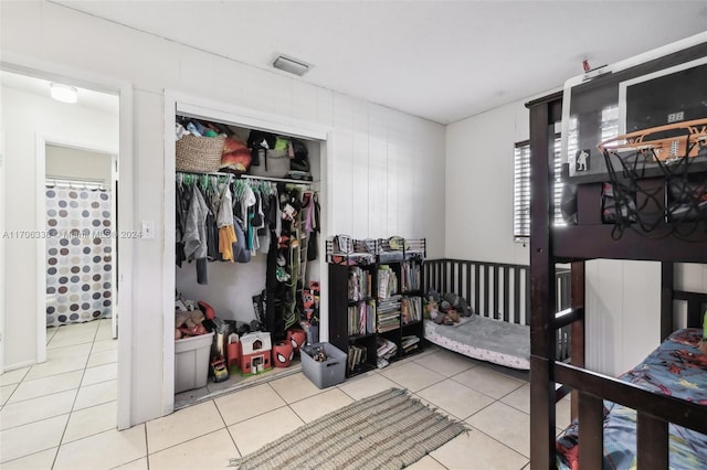 bedroom featuring light tile patterned floors and a closet