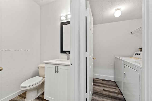 bathroom featuring vanity, independent washer and dryer, a textured ceiling, and hardwood / wood-style flooring