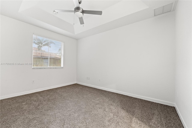 spare room with carpet, ceiling fan, and a tray ceiling