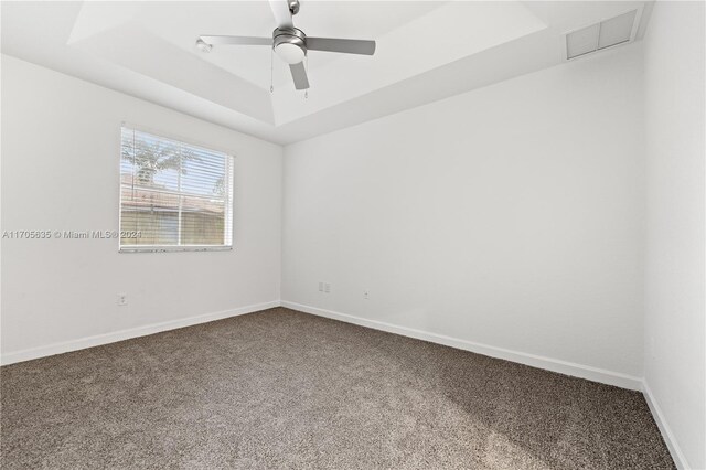 1476 SE 26th Ave, Homestead, FL 33035 - spare room featuring a tray ceiling, dark carpet, and a ceiling fan