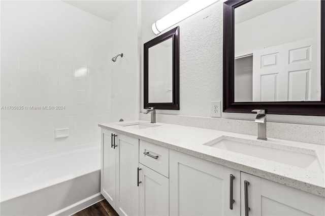 bathroom featuring vanity, wood-type flooring, and tiled shower / bath