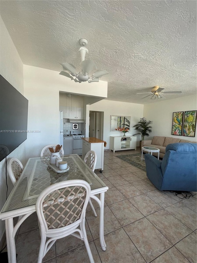 dining area with light tile patterned floors, a textured ceiling, and ceiling fan