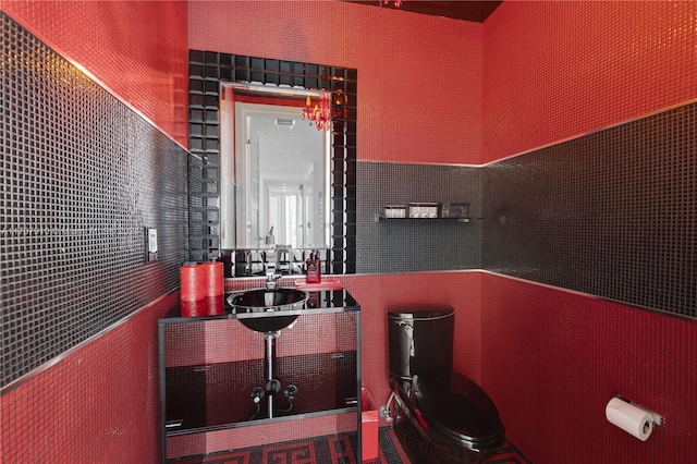 bathroom with sink, tile walls, and toilet