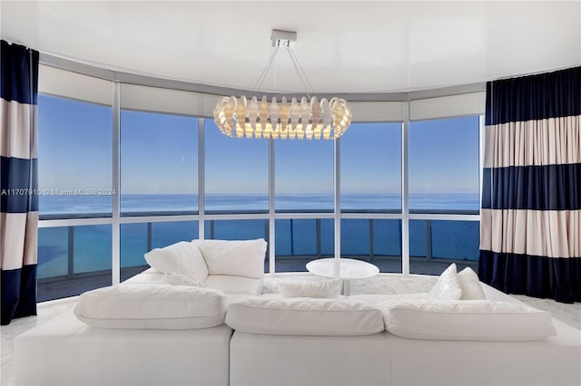 living room featuring a notable chandelier, floor to ceiling windows, and a water view