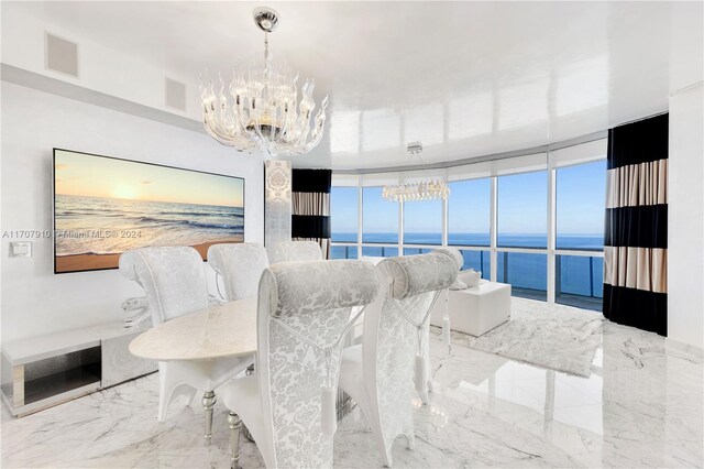 dining area featuring expansive windows, a water view, and a notable chandelier