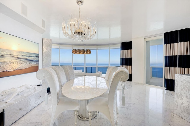 dining room featuring a notable chandelier, expansive windows, a water view, and a wealth of natural light