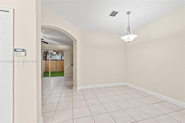 tiled spare room featuring ceiling fan