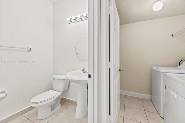 bathroom with tile patterned flooring, a textured ceiling, separate washer and dryer, and toilet