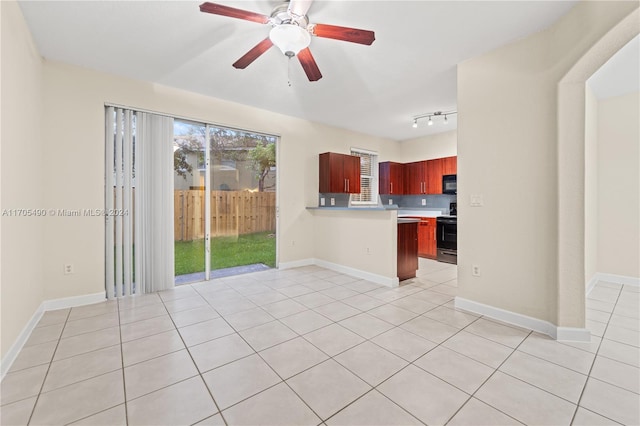 unfurnished living room with track lighting, ceiling fan, and light tile patterned flooring