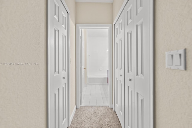 hall featuring light colored carpet