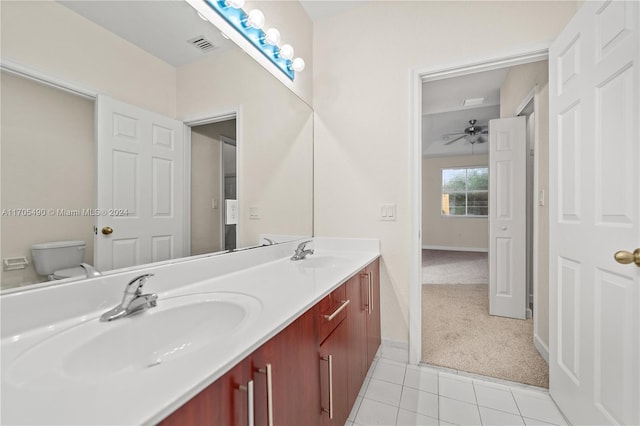 bathroom with toilet, vanity, tile patterned floors, and ceiling fan