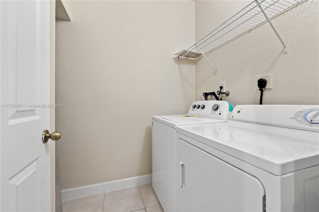 laundry room featuring light tile patterned flooring and washing machine and dryer