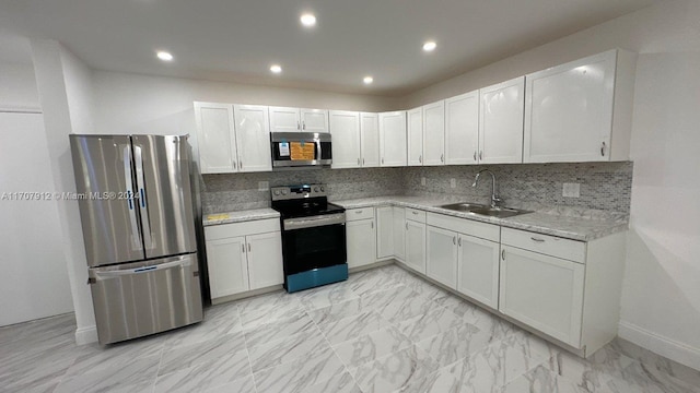 kitchen with white cabinets, stainless steel appliances, tasteful backsplash, and sink