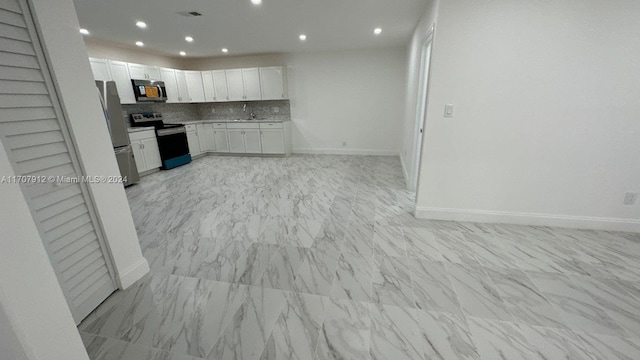 kitchen featuring white cabinets, decorative backsplash, stainless steel appliances, and sink