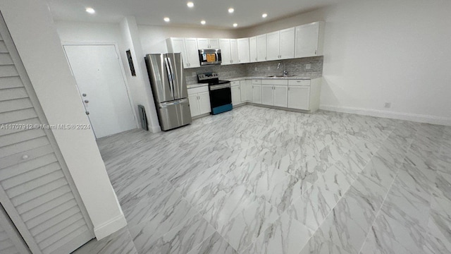 kitchen featuring white cabinets, decorative backsplash, stainless steel appliances, and sink