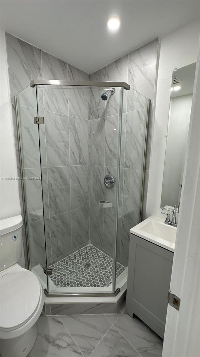 bathroom with vanity, an enclosed shower, and toilet