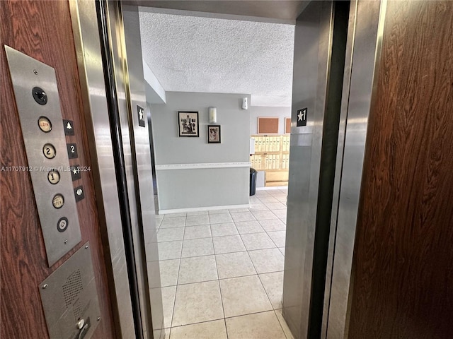 corridor featuring light tile patterned floors and a textured ceiling