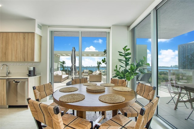 dining space featuring expansive windows and sink