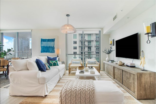 living room featuring floor to ceiling windows and light hardwood / wood-style floors