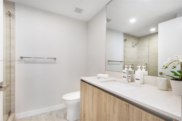 bathroom featuring hardwood / wood-style floors, vanity, an enclosed shower, and toilet