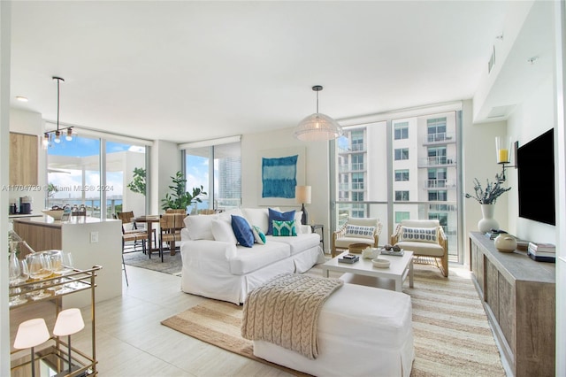 living room with expansive windows, plenty of natural light, and a notable chandelier