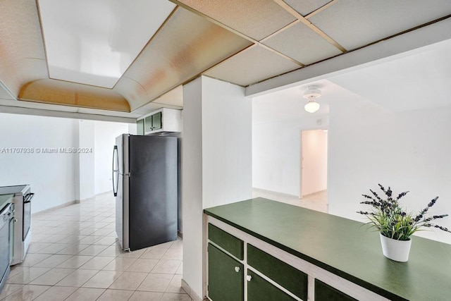 kitchen with electric range, dishwasher, stainless steel fridge, and light tile patterned flooring