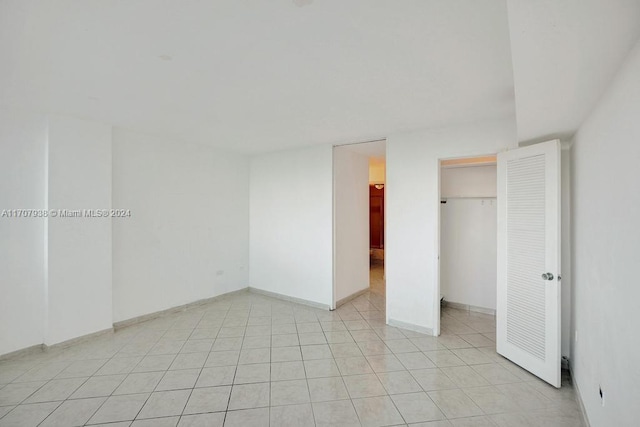 unfurnished bedroom with a closet and light tile patterned floors