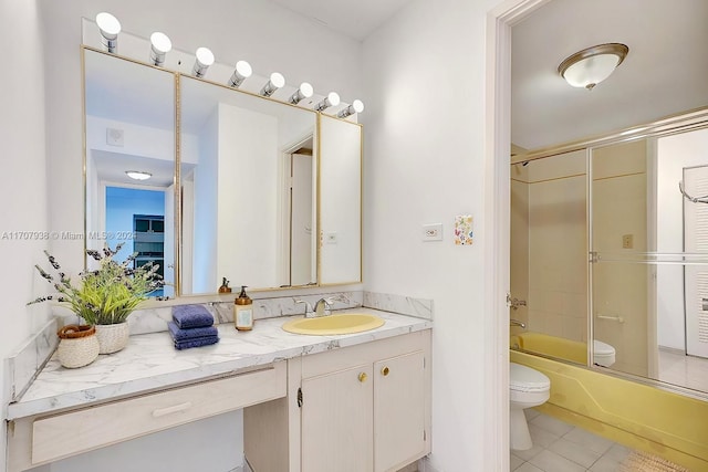 full bathroom featuring shower / bath combination with glass door, vanity, tile patterned floors, and toilet