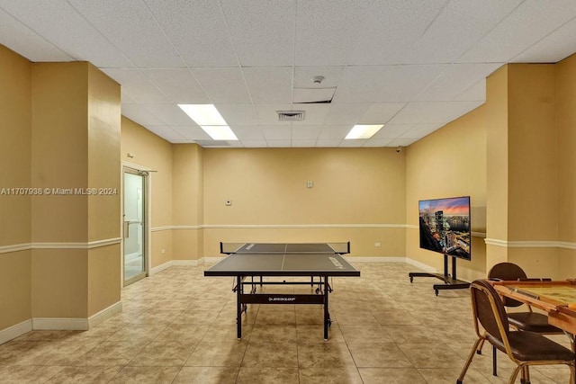 rec room with light tile patterned floors and a paneled ceiling