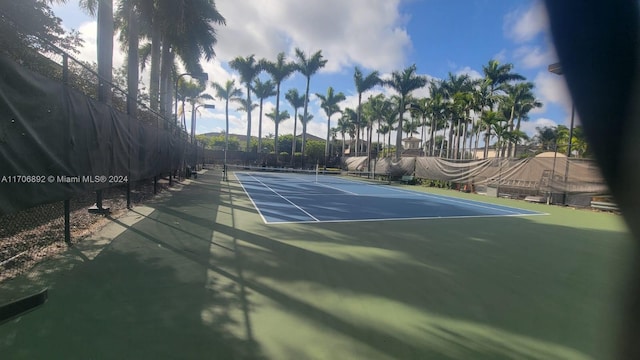 view of tennis court featuring basketball hoop