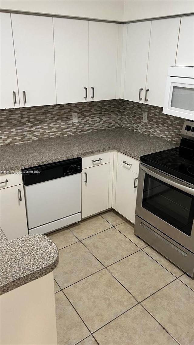 kitchen with white appliances, decorative backsplash, white cabinets, and light tile patterned flooring