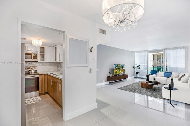 tiled living room featuring sink and a chandelier