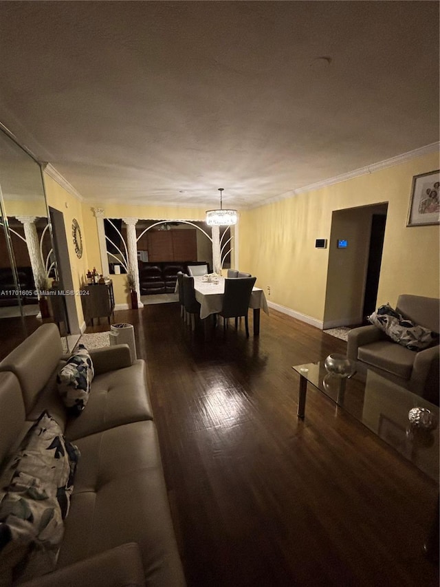 living room featuring hardwood / wood-style flooring, an inviting chandelier, and crown molding