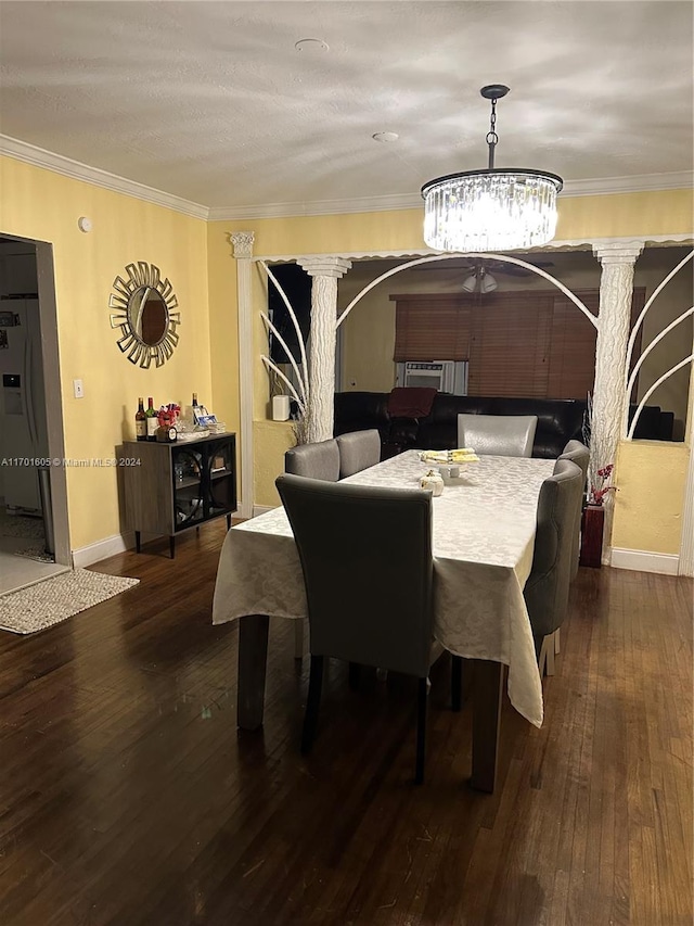 dining room featuring decorative columns, ornamental molding, a chandelier, and hardwood / wood-style flooring