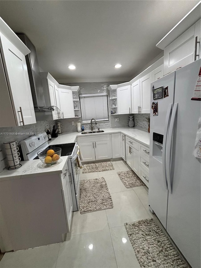 kitchen with tasteful backsplash, white appliances, sink, white cabinetry, and light tile patterned flooring