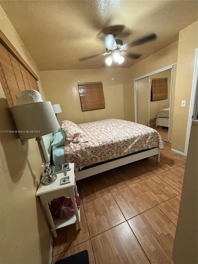 bedroom with ceiling fan, a textured ceiling, and a closet