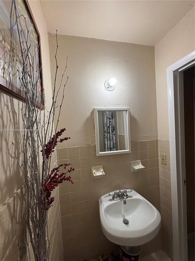 bathroom with sink and tile walls