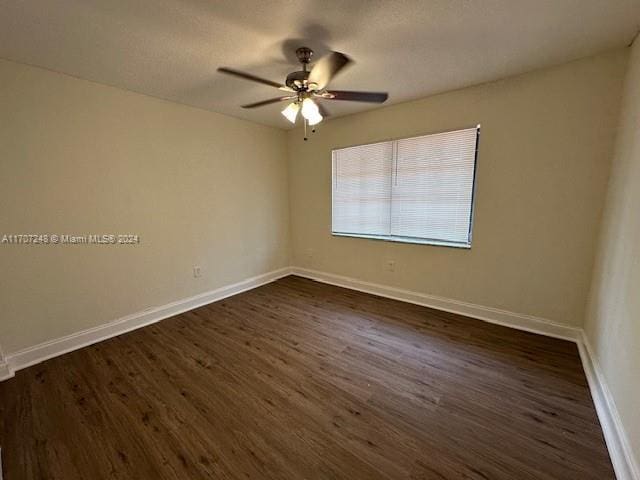 spare room with ceiling fan and dark hardwood / wood-style floors