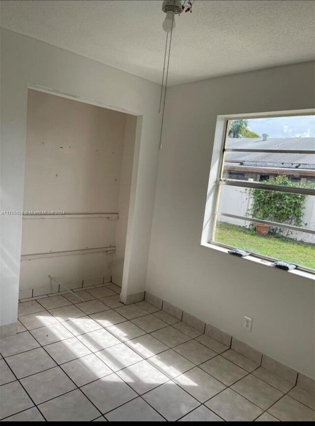 4575 Gladiator Cir, Green Acres, FL 33463 - unfurnished room with light tile patterned flooring and a textured ceiling