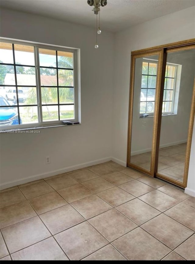 4575 Gladiator Cir, Green Acres, FL 33463 - empty room featuring light tile patterned floors and baseboards