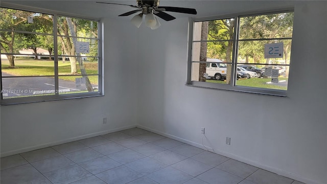 spare room featuring ceiling fan and light tile patterned floors