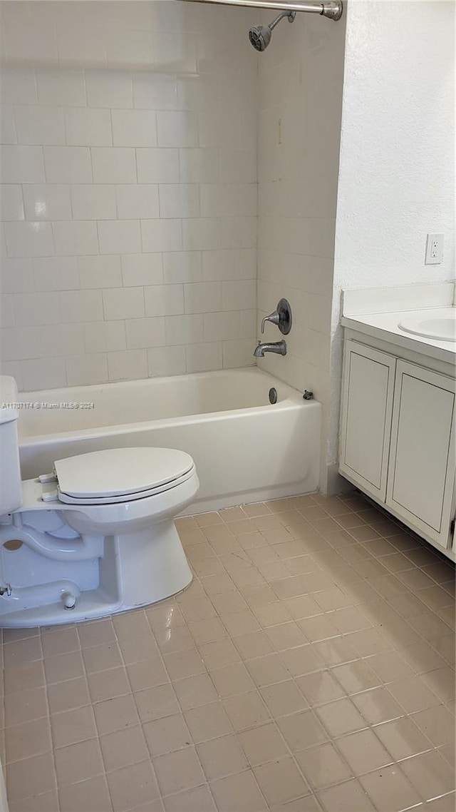 full bathroom featuring toilet, tile patterned flooring, vanity, and tiled shower / bath