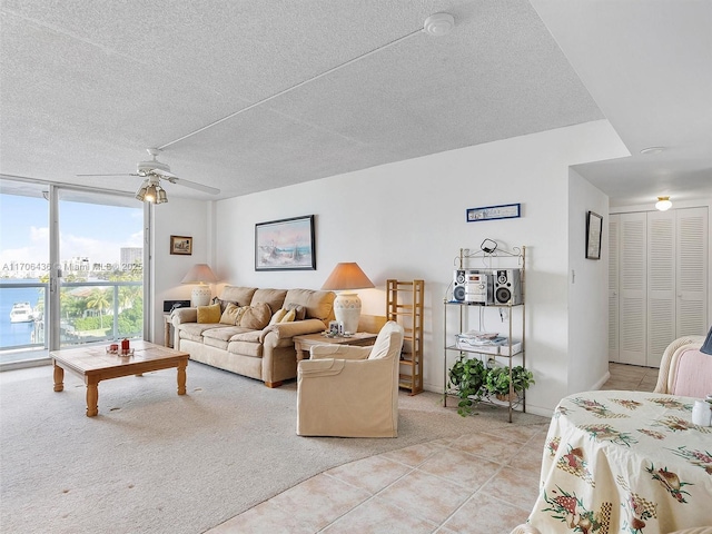 tiled living room featuring floor to ceiling windows, ceiling fan, and a textured ceiling