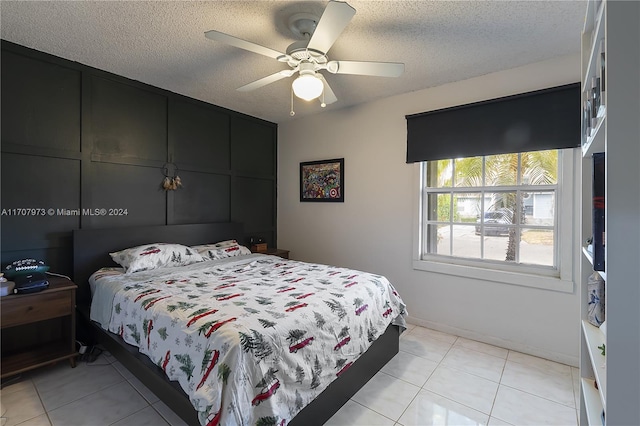 tiled bedroom with a textured ceiling and ceiling fan