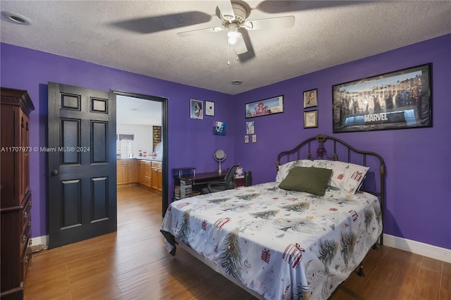 bedroom with hardwood / wood-style floors, ceiling fan, and a textured ceiling