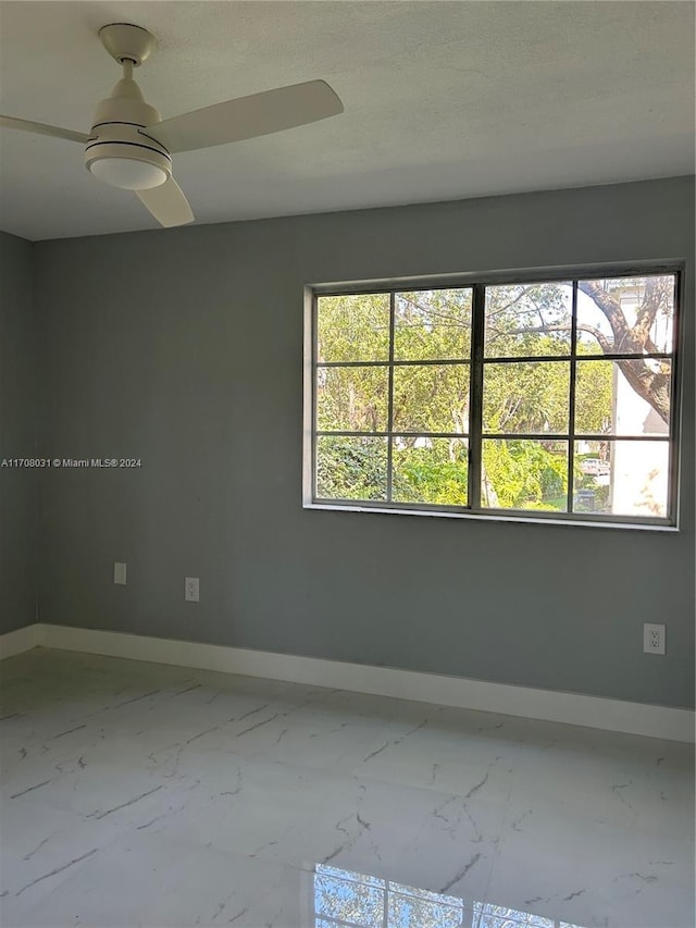 empty room featuring ceiling fan and a textured ceiling