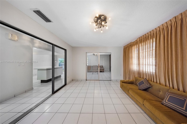 unfurnished living room featuring plenty of natural light, light tile patterned floors, and a textured ceiling