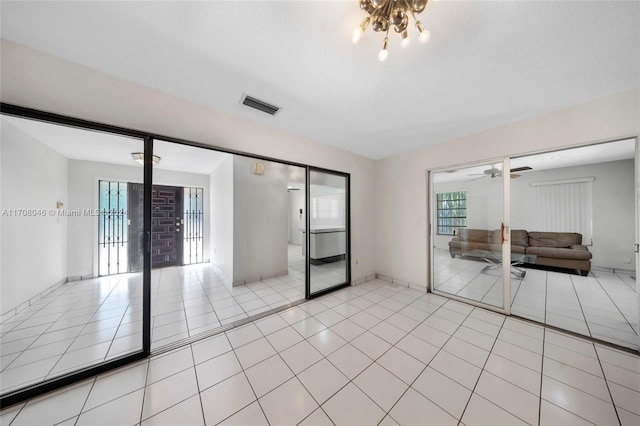 empty room featuring light tile patterned floors and ceiling fan