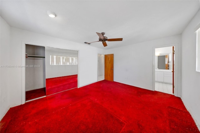 unfurnished bedroom with carpet, a closet, ensuite bath, and ceiling fan